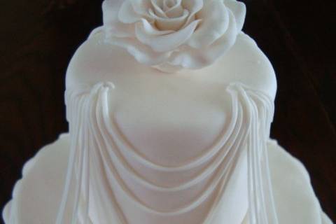 Elegant wedding cake with string work and roses.
