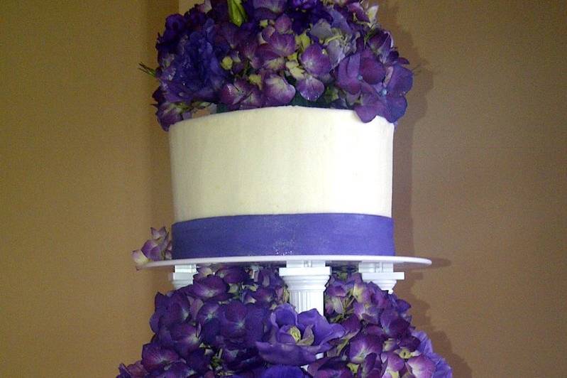Beautiful purple hydrangeas and mixed flowers Wedding Cake.  Columns to add height to the cake.