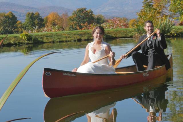 Bride and groom pose in canoe