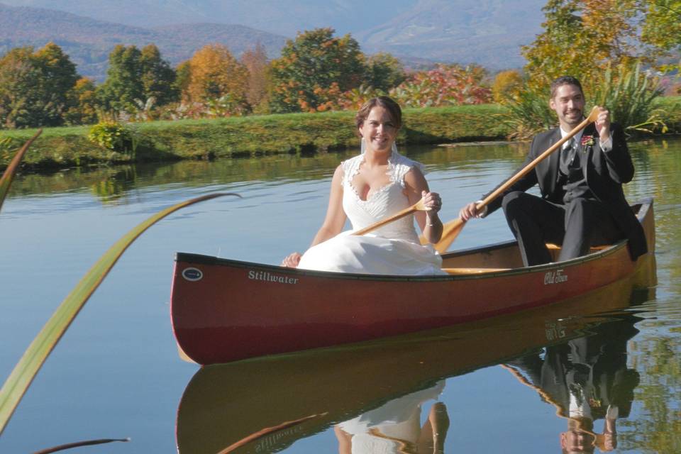 Bride and groom pose in canoe