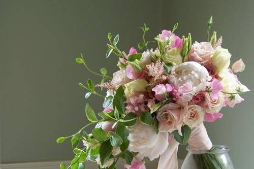 hand tied, cascade bridal bouquet containing peonies, sweet peas, astilbe, lisianthus, dahlias, Eos roses, Sweet Eskimo roses, White Mikado spray roses, and foliage cut from the garden
