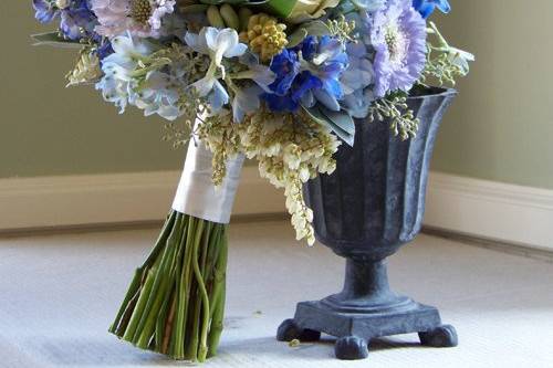 bridal bouquet with dark blue and light blue delphinium, blue scabiosa, tweedia, pale blue hydrangea, pieris, tuberose, Cream Prophyta roses, seeded eucalyptus, silver tree, wormwood, and succulents