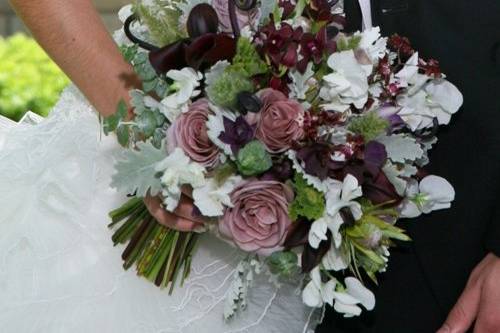 bridal bouquet containing white sweet peas, amnesia roses, Schwartzwalder mini callas, Burana Sindy dendrobium orchids, fern curls, Sharry Baby oncidium orchids, scented geranium, green leucadendron, bunny grass, baby blue eucalyptus and dusty miller