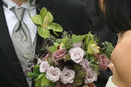 Hand-tied bridal bouquet with lavender hellebores, Amnesia roses, blackberries, Pachyveria glauca ‘Little Jewel’, seeded eucalyptus, and scented geranium, finished with a fawn satin wrap
