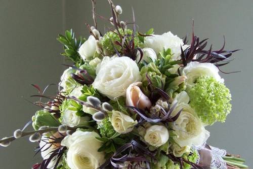 bouquet with bright green viburnum, white hyacinth, peach Menton French tulips, green parrot tulips, white ranunculus, French pussy willow, Snow Dance spray roses, euonymus foliage and deep purple agonis