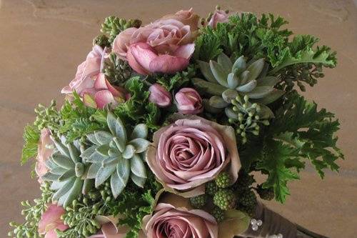 Hand-tied bridal bouquet with lavender hellebores, Amnesia roses, blackberries, Pachyveria glauca ‘Little Jewel’, seeded eucalyptus, and scented geranium, finished with a fawn satin wrap