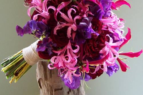 hand-tied bouquet with Hearts roses, Rubicon spray roses, gloriosa lilies, nerine lilies, and sweet peas