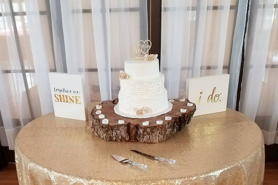 Cake table w/ gold sequin tablecloth and XL wood slab and votives