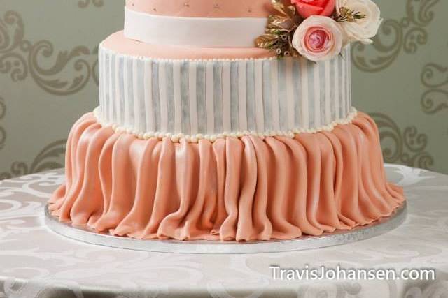 Classic romance: 5 tiered wedding cake featuring draping, vertical stripes, quilting, hand piped brushed embroidery, and hand piped scroll work finished with fresh floral accents.