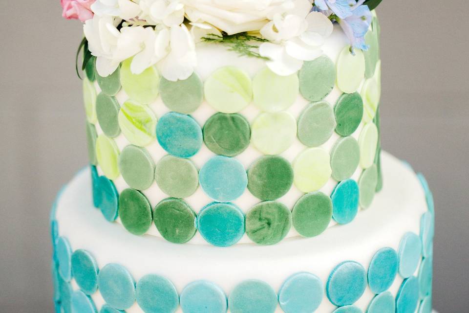 Water color inspired wedding cake with a modern contemporary twist. Fresh floral accents and geometric circle cutouts are perfect details for this classic cake.