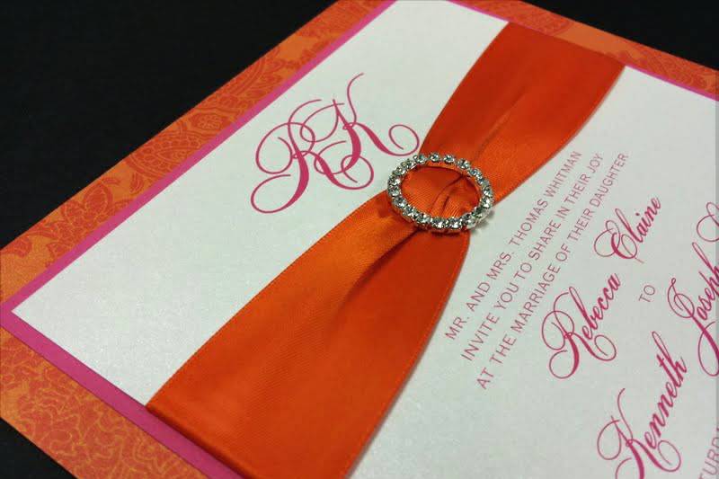 Rebecca and Kenneth - Envelopments 3-layer card with wide orange satin ribbon and rhinestone buckle.