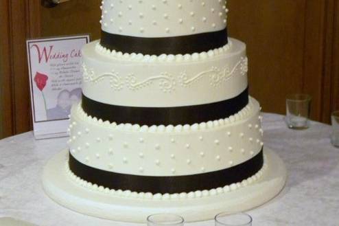 4 tiered buttercream with swiss dot and scroll design, chocolate brown satin ribbon trim