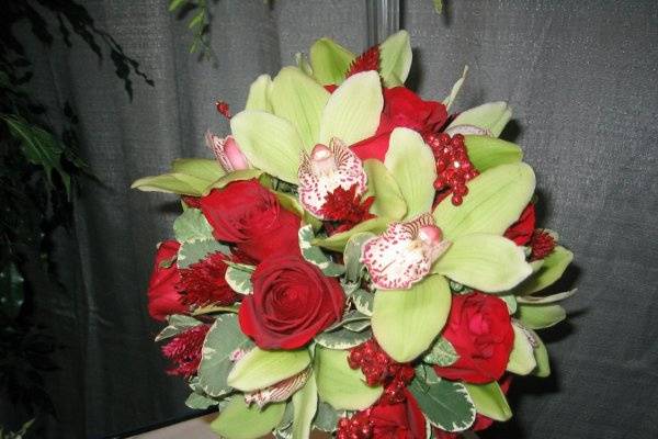 Cymbidium orchids and red roses.  Colorful yet elegant.