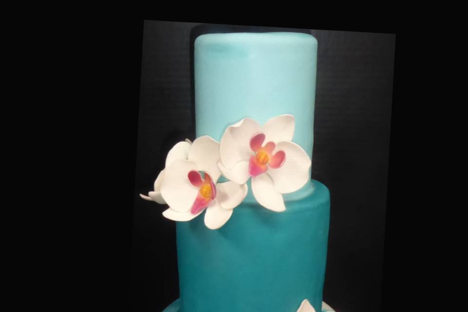 3 tier blue fondant cake with marbled blue and white fondant bottom tier, white sugar moth orchids