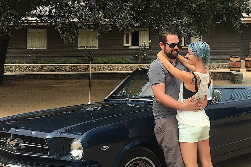 Couple posing with blue mustang