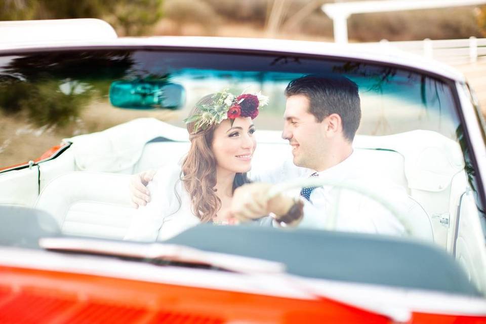 Couple driving red convertible