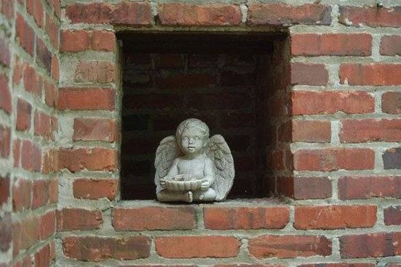 A stone cherub tucked into a nook off the Manor's terrace.