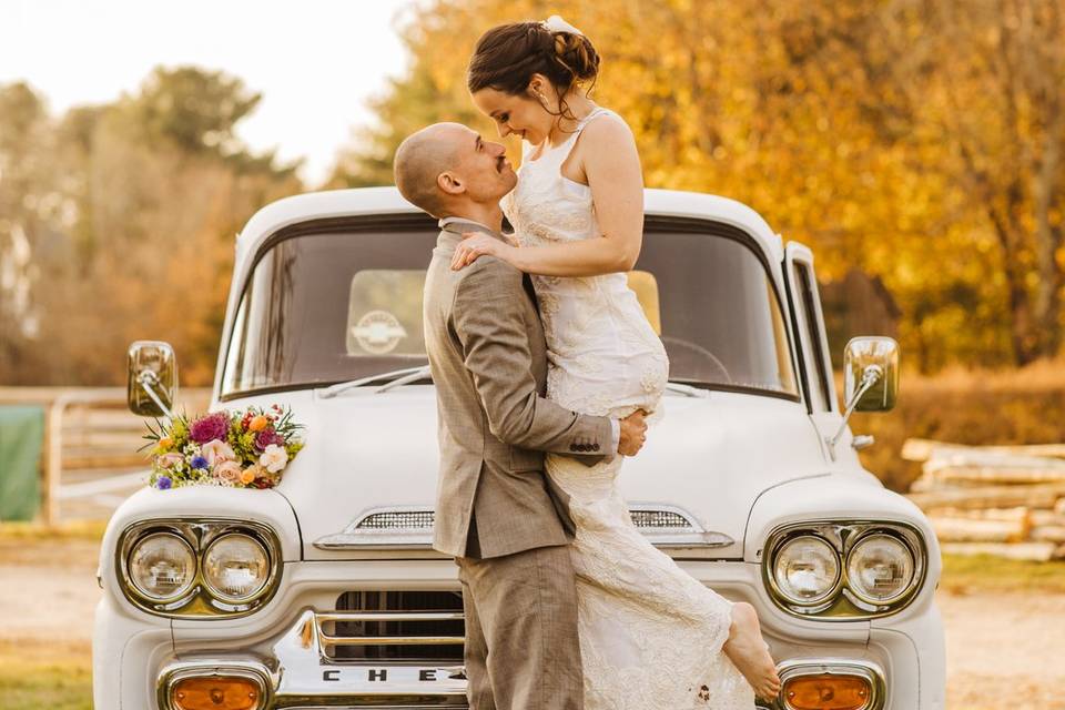 Newlyweds by a vintage car