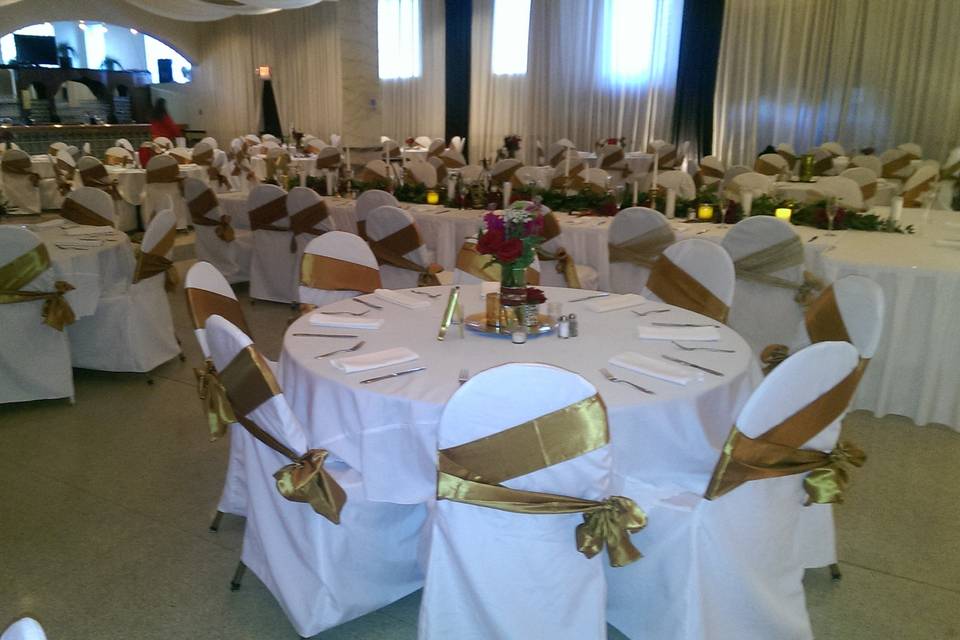 Floral centerpiece and gold chair bows