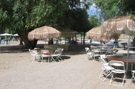 Palapa covered umbrellas for guest seating in London Bridge Beach Park