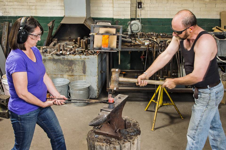 Nicole and Harry hammering hot steel.