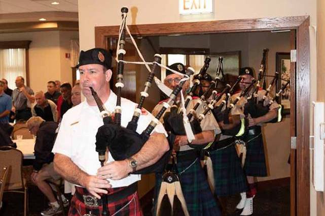 Bagpiper leading a band