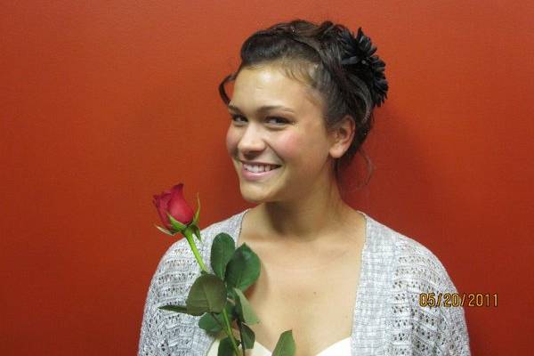 Fun up and easy...with lose pinned curls in the back with large black flower to match her fun dress for prom