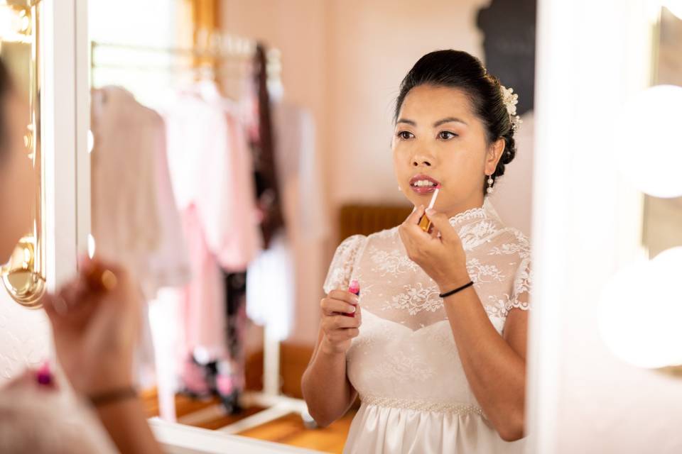 Bride applying makeup
