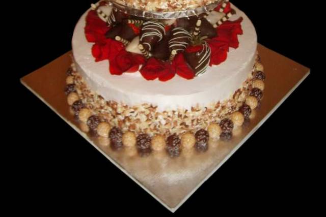 This cake features roses and chocolate covered strawberries. The top tier is tiramisu and the bottom is Italian cream
