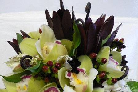 Bridal bouquet of green cymbidium orchids, monkey tails, saffarri sunset, alstomeria lillys and hypericum