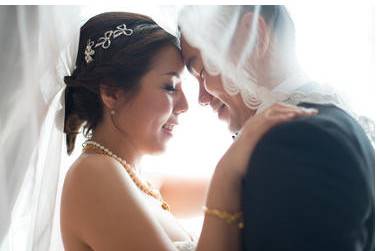 Bride and groom under veil