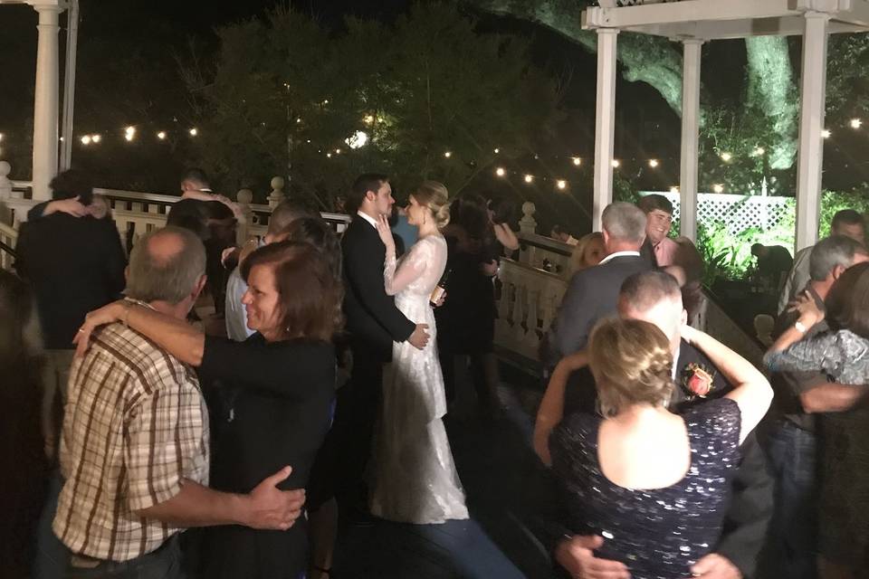 Guests and newlyweds slow dancing