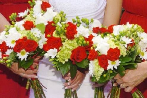 Red roses, green hydrangeas, white daisies with open stem attendant bouquets by Loeffler's Flowers