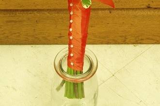 Gerbera daisies with pitt greens with wrapped stems attendant bouquet by Loeffler's Flowers