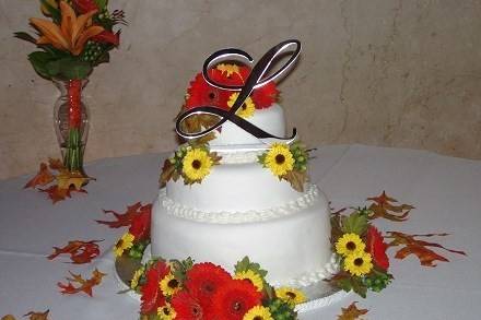 Cake flowers of orange gerbera daisies and Viking mums & green hypericum berries by Loeffler's Flowers