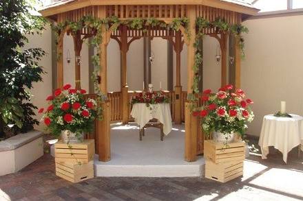 Ceremony flowers at a gazebo - garlands, floral bouquets and unity candle flower arrangement by Loeffler's Flowers