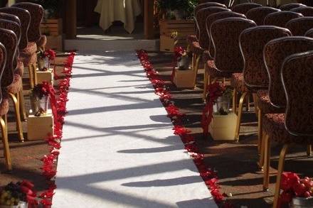 Ceremony - red rose petals lining aisle runner and vased arrangements by Loeffler's Flowers