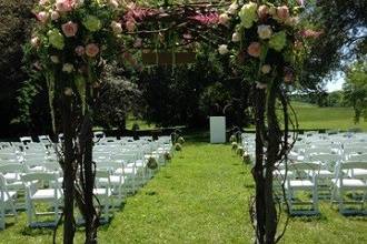 Ceremony - wedding arbor decorated with two corner rose florals by Loeffler's Flowers