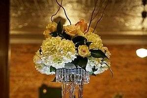 This dramatic centerpiece was published in the Spring '08 issue of the Knot magazine.  The arrangement is made up of white hydrangea, champagne and ivory roses with unique beaded crystals on uplit pilnser vase with submerged branches. These modern details make an otherwise traditional design much more exciting.