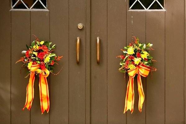 A pair of fall inspired floral arrangements for the front doors of the church.  These include roses, berries, dahlias, interesting foliage and a fine silk ribbon in the bride's colors.