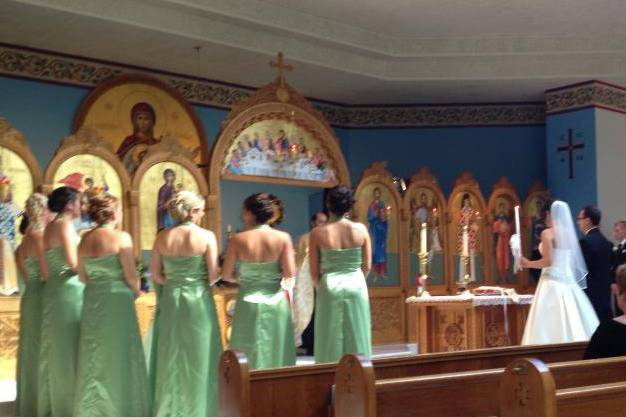 Bridesmaids in their peridot color bridesmaids gowns at the alter