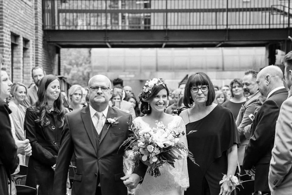 Parents walking with the nearly wed down the aisle