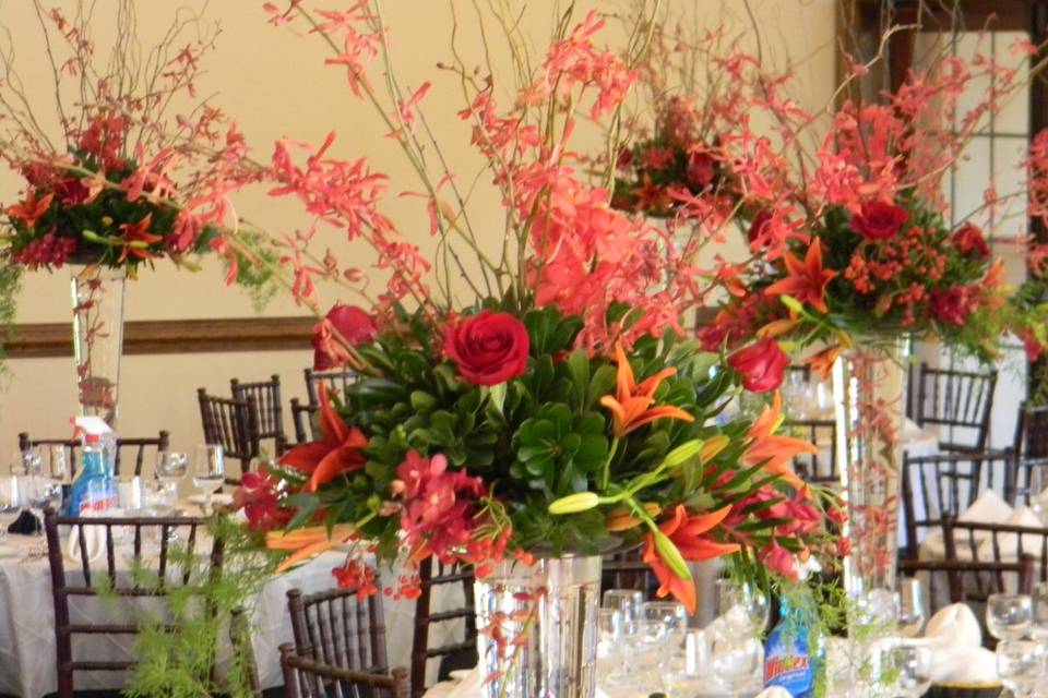 Tall centerpieces with orchids, lilies, roses and greens