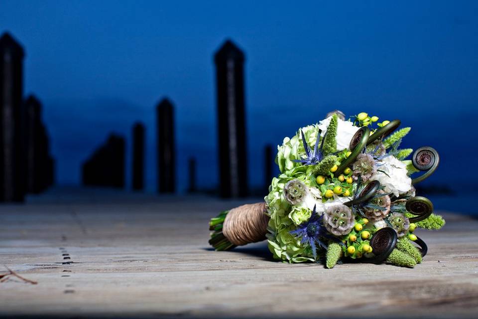 Shite lisianthus, green hypericum berry, green hydrangea, uhele fern, scabiosa pods, blue thistle and green millet. This was for an organic wedding