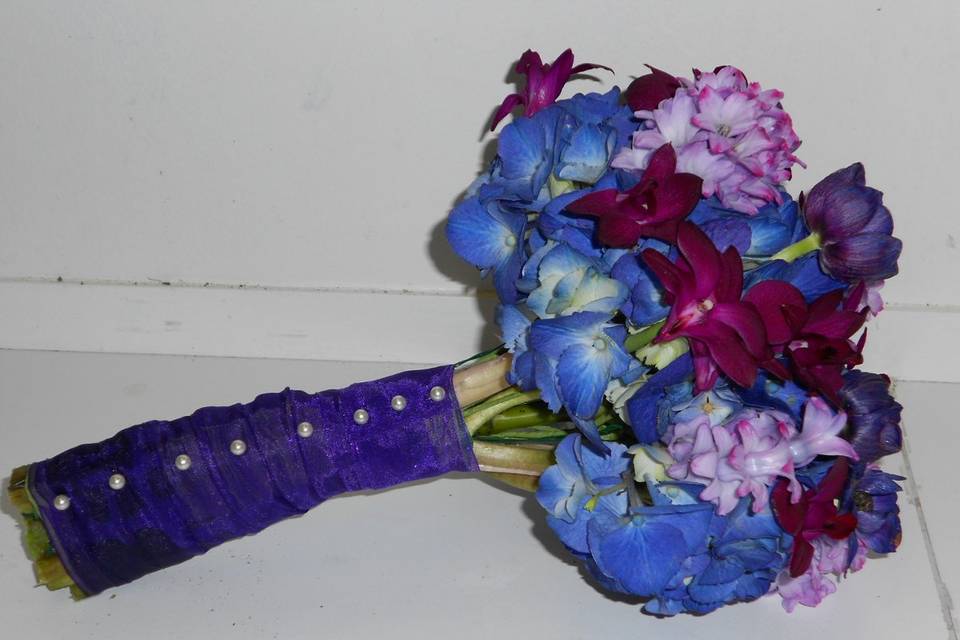 Bridal bouquet with purple hydrangea, dark purple orchids, purple anenomes and purple hyacinth blooms