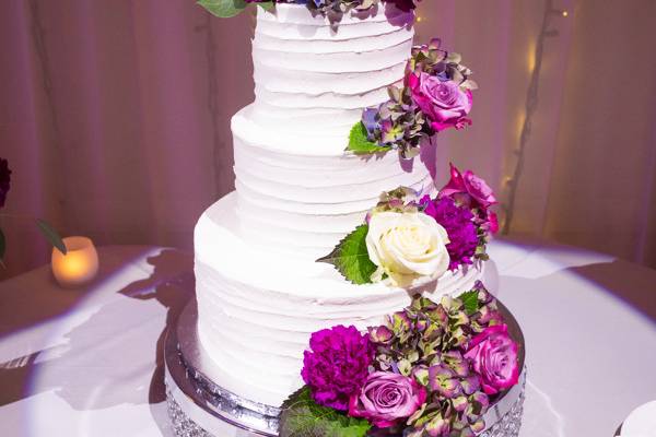 Spotlighted cake with purple flowers