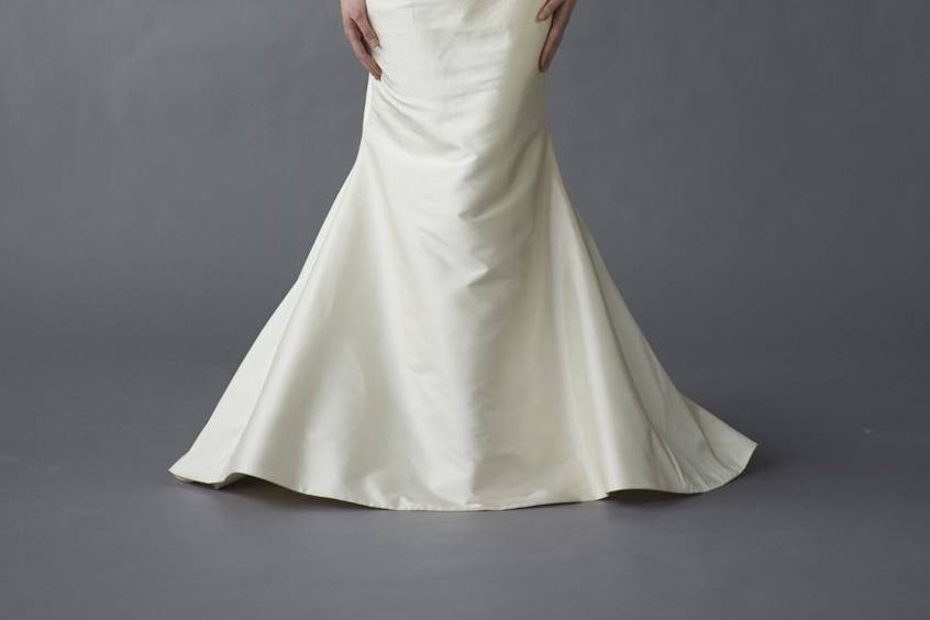 Caroline DeVillo - Kate - Float down the aisle in this dupioni-silk mermaid gown with a chapel train. Ripples of asymmetrical ruching and buttons add movement and contrast to its alluring curves.