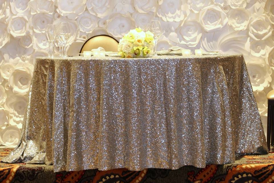 Sweethearts' table in front of a flower wall