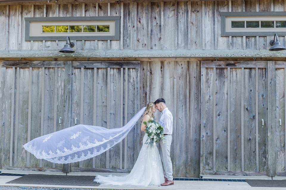 Bride and groom outside barn.
