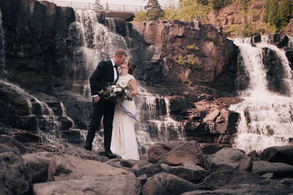 Couple standing before waterfalls